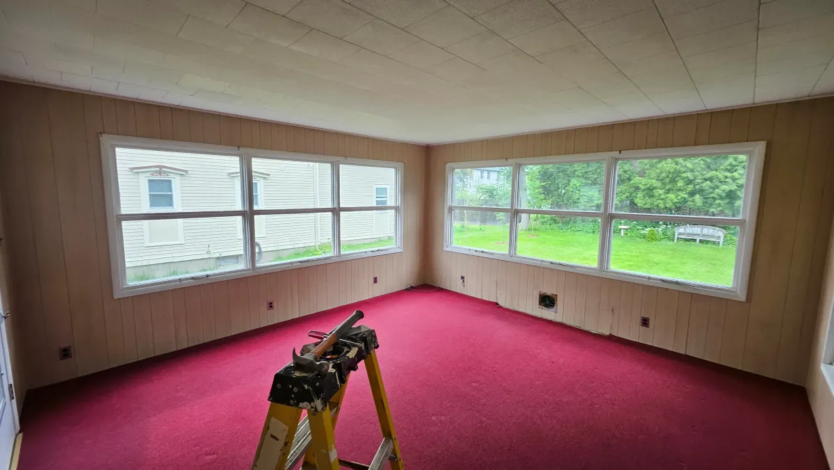 Dated sunroom with pink carpet before renovation